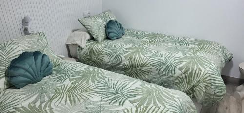 a bedroom with two beds with green leaves at Casa del Pilar in Pinto