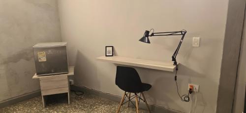 a desk with a black lamp and a chair at Casa Agena in Cartagena de Indias