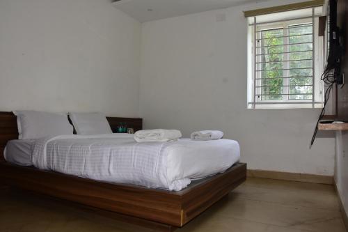 a bedroom with a bed with two towels on it at Bihotels And Resorts in Yercaud