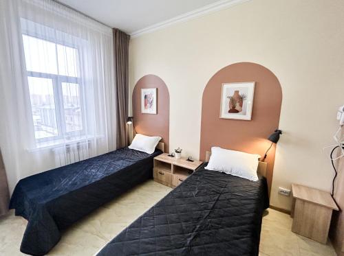 a room with two beds and a window at Bekarys Twins in Astana