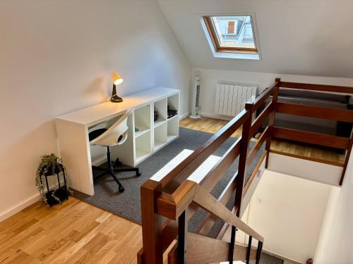 an attic room with a desk and a staircase at Maison Cosy à Chartres in Chartres