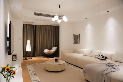 a white living room with a couch and a table at Merit黄浦 Bright and Modern 2Bed Condo unit in downtown Shanghai in Shanghai