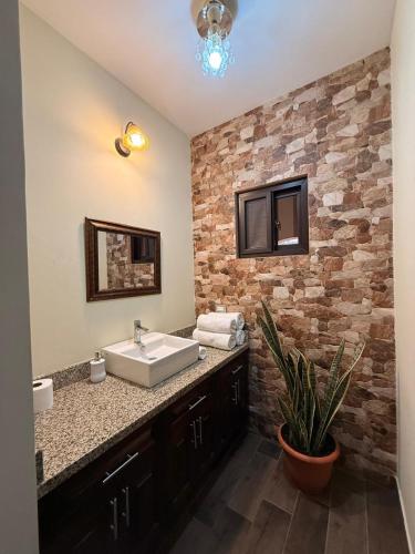 a bathroom with a sink and a brick wall at Hotel y Restaurante Vista Verde in Santa Lucía Milpas Altas
