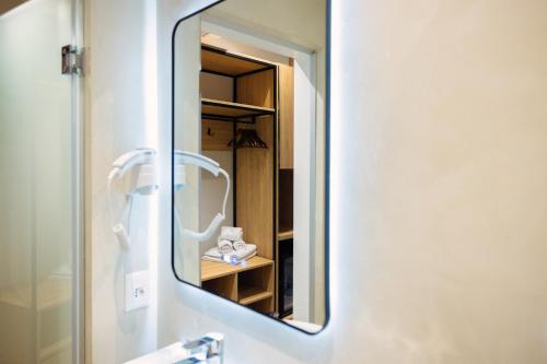 a mirror on a wall in a bathroom at Hotel Relax City Center in Tirana