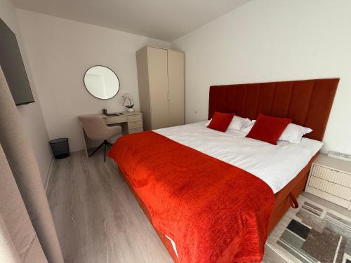 a bedroom with a large bed with a red blanket at IDDA Concept 3 in Târgu-Mureş