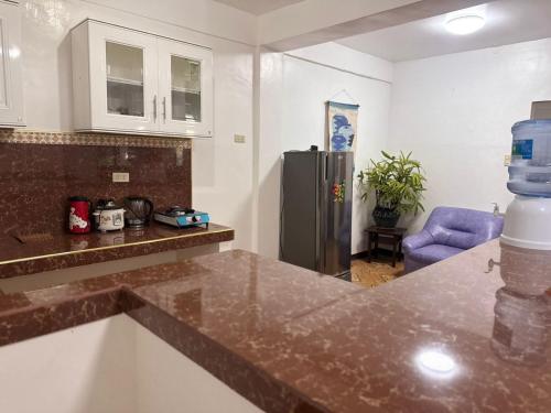 a kitchen with a counter top and a refrigerator at Mabel's Garden Stay in Puerto Galera