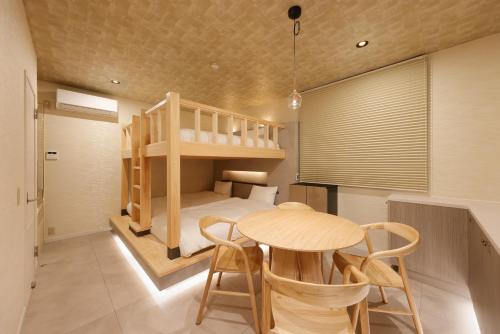 a small room with a bunk bed and a table and chairs at HAKORU Tokyo 八炬ル in Tokyo