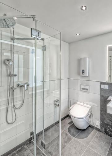 a bathroom with a glass shower and a toilet at Unperfekthotel CoWorkingHotel in Essen