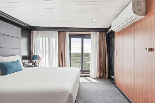 a bedroom with a large bed and a large window at Aqua Classic Cruise in Ha Long