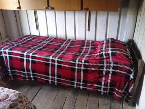 a red blanket sitting on top of a wooden floor at El Atardecer in Lunarejo