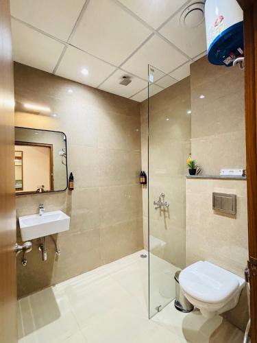 a bathroom with a shower and a toilet and a sink at Arth Suites Lucknow Gomti Nagar in Lucknow