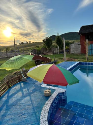 two umbrellas sitting next to a swimming pool at El Atardecer in Lunarejo