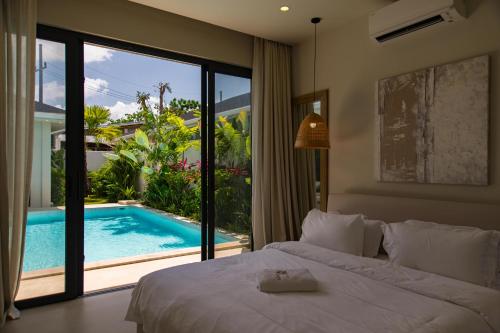 a bedroom with a bed and a swimming pool at Valentine Village in Choeng Mon Beach