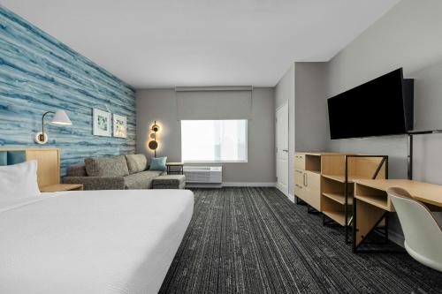 a hotel room with a bed and a flat screen tv at TownePlace Suites by Marriott Pell City in Pell City