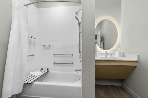 a bathroom with a tub and a sink and a mirror at TownePlace Suites by Marriott Pell City in Pell City