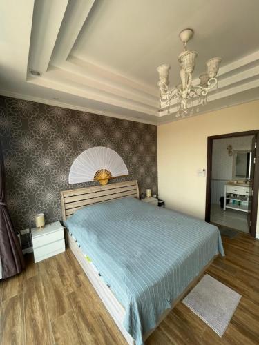 a bedroom with a large bed and a chandelier at Dans den in Pai