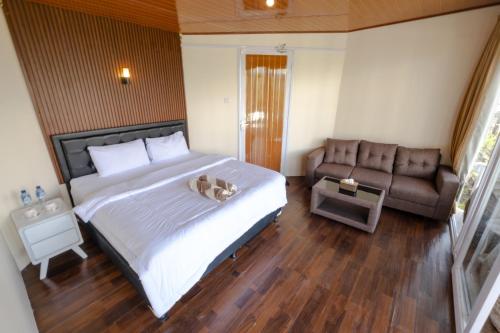 a bedroom with a large bed and a couch at La Pino Mount Batur and Hot Spring in Bangli