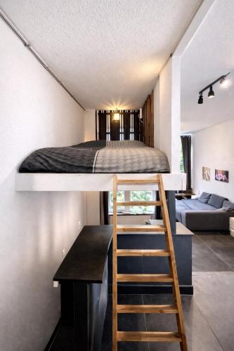 a loft bed in a small room with a desk at Loft appartement centrum Dordrecht nieuw 2026 in Dordrecht