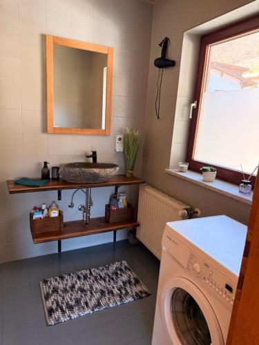 a bathroom with a sink and a washing machine at Chalet Ad Alta - Flattach in Flattach