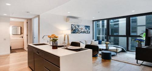 a kitchen and living room with a couch and a table at Luxe 46th Level 2 Bedroom CBD Apartment with Pool Gym Spa and Views in Melbourne