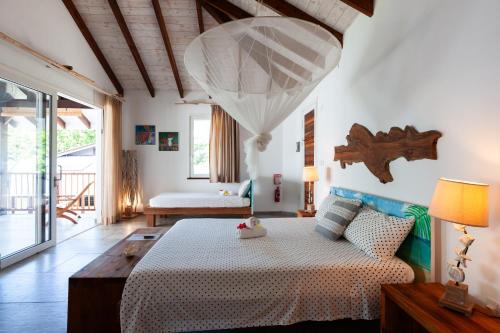 a bedroom with a bed and a couch in a room at Reve Island Lodge in Grand Anse