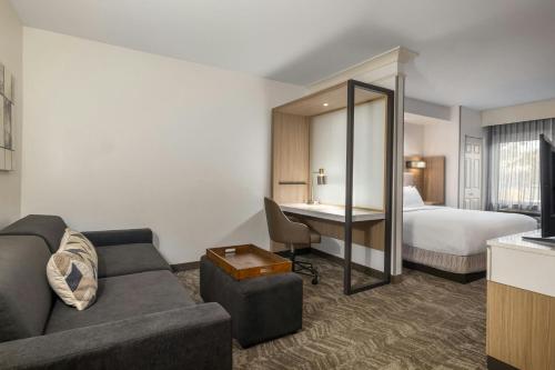 a hotel room with a couch and a bed at SpringHill Suites Fresno in Fresno