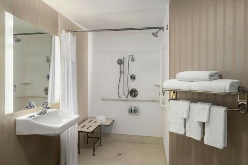 a white bathroom with a sink and a shower at SpringHill Suites Fresno in Fresno