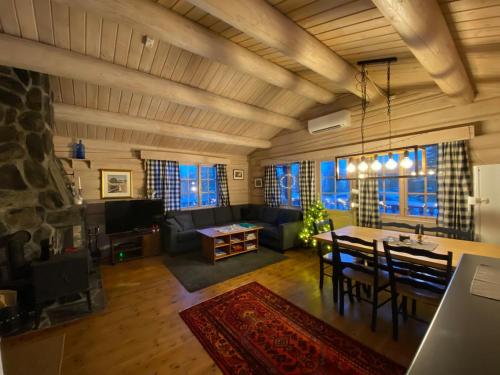 a dining room and living room with a table and chairs at Synnfjell hytta in Nord Torpa