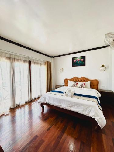 a bedroom with a large bed with a wooden floor at Win Hotel Vang Vieng in Vang Vieng