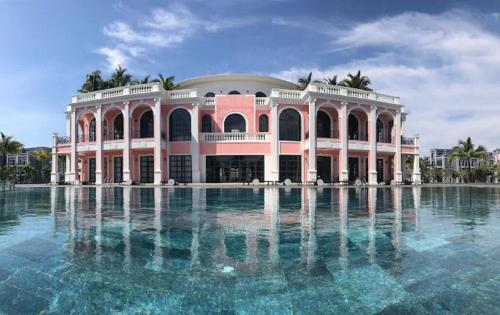 a large building with water in front of it at Canisa Villas in Phú Quốc