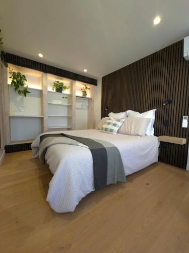 a bedroom with a large bed with white blankets and pillows at The Old Tin Shed in Wanaka