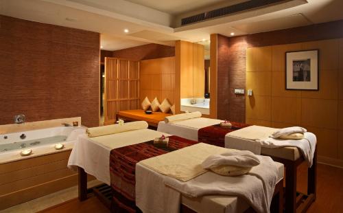 y baño con 4 camas y bañera. en Ellaa Hotel Gachibowli, en Hyderabad