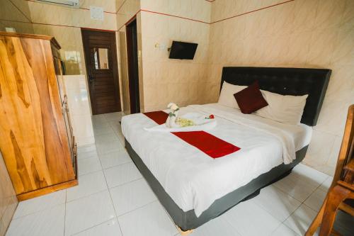 a bedroom with a bed with a tray of food on it at Santhi Graha Guest House in Legian