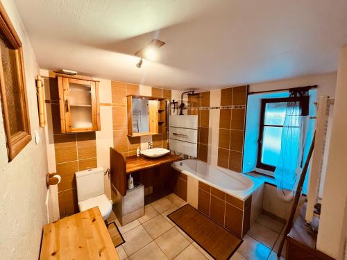 a bathroom with a tub and a sink and a toilet at Gîte Les sources proche Annecy in Vaulx