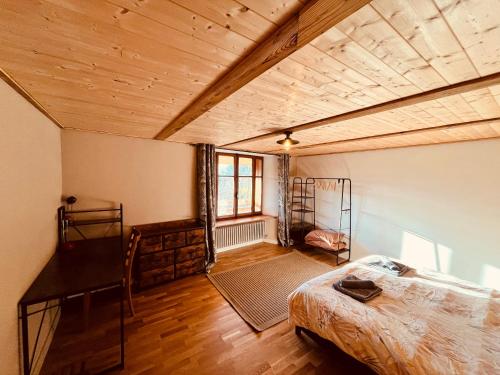 a bedroom with a bed and a wooden ceiling at Gîte Les sources proche Annecy in Vaulx