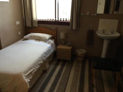 Tempat tidur dalam kamar di Belhaven Private Hotel