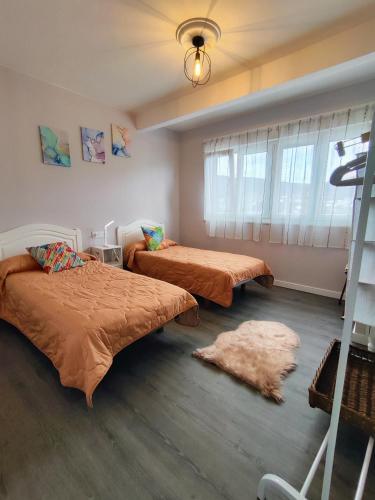 a bedroom with two beds and a rug at Piso en el centro de Viveiro in Viveiro