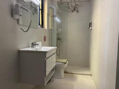 a bathroom with a sink and a toilet and a shower at Sunrise story in Artemida