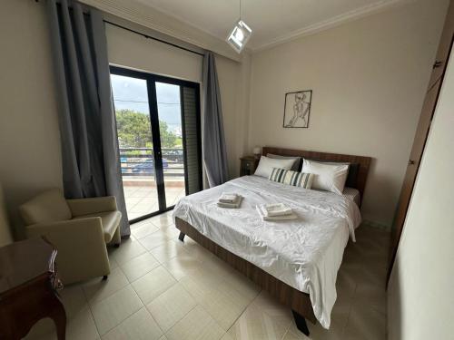 a bedroom with a bed and a large window at Sunrise story in Artemida