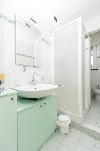 a white bathroom with a sink and a mirror at Apartment Vincenzina in Monterosso al Mare