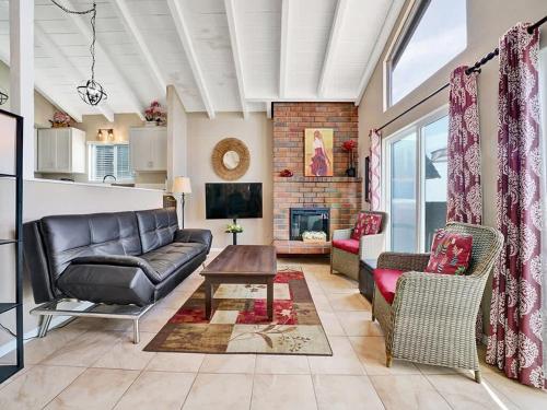 a living room with a couch and a fireplace at Oceanfront withIncredible Beach Views home in Newport Beach