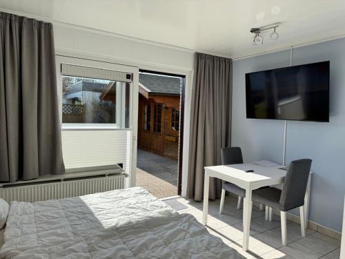 a bedroom with a bed and a desk and a television at Bungalow Löwenstrom in Büsum