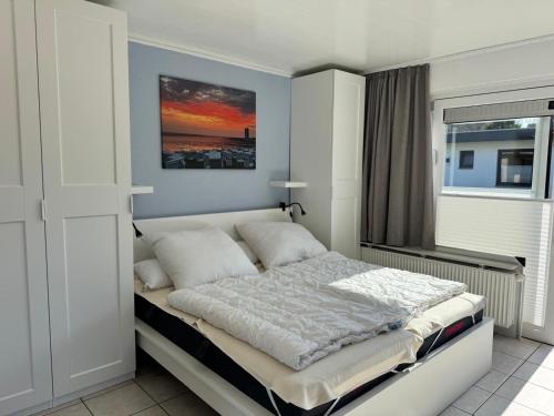 a bedroom with a large bed with a window at Bungalow Löwenstrom in Büsum