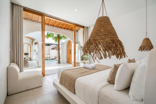 a bedroom with a large bed and a chair at CODYARD LUXURY SUITES, close to Seseh Beach in Munggu