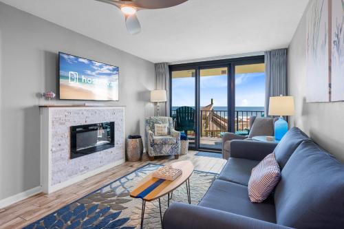 a living room with a blue couch and a fireplace at Phoenix II 2012 in Orange Beach