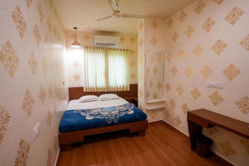 a small bedroom with a bed and a window at Hotel Tulsi in Nadiād