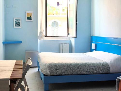 a blue bedroom with a bed and a window at Banchi Centrale in Riomaggiore