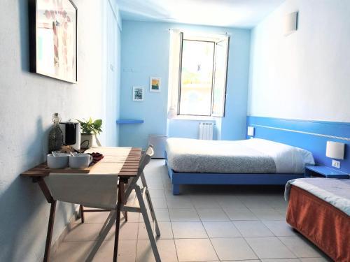 a blue room with a bed and a table and a bed sidx sidx sidx at Banchi Centrale in Riomaggiore