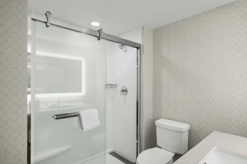 a bathroom with a shower with a toilet and a sink at SpringHill Suites by Marriott Fort Collins in Fort Collins