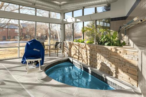 a swimming pool in the middle of a patio with a blue chair at SpringHill Suites by Marriott Fort Collins in Fort Collins